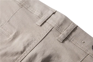 Detail of khaki cotton trousers showing waist loops and high-density double stitching