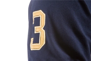 Detailed macro shot of premium navy pique cotton fabric with golden number 3 embroidery
