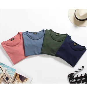 Flat lay of four colorful slub cotton t-shirts with summer travel accessories