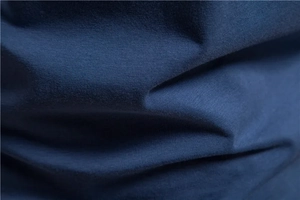 Close-up of navy blue cotton knit fabric texture and high-quality stitching on T-shirt