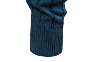 Vue macro détaillée de la manche du pull en maille bleu marine et du poignet côtelé