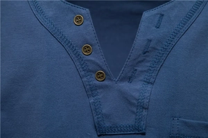 Detailed close-up of blue Henley T-shirt with textured knit fabric and bronze buttons