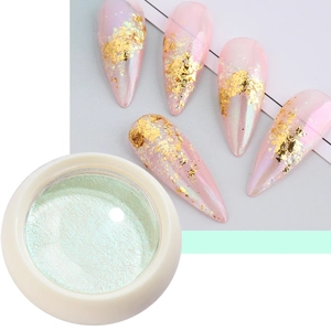 Close-up of pearl green nail aurora powder in a jar with gold foil nail art samples