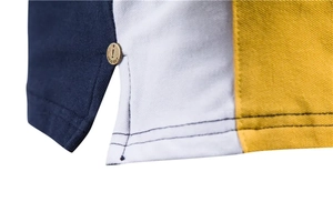 Detail of piqué cotton polo shirt side slit with tricolor design and engraved metal button