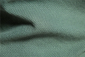 Macro texture of sage green knit fabric showing detailed weave and soft draping quality