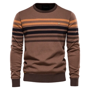 Detail of round neck knit sweater featuring contrast stripes and round metal logo piece