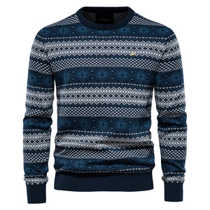 Detail of navy knit sweater showing white Fair Isle snowflake patterns and crew neck design