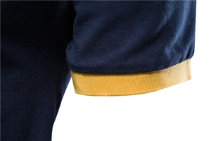 Close-up of navy blue pique cotton polo shirt with yellow ribbed knit cuff detail