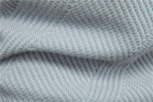 Macro shot of grey knitted fabric with clear herringbone pattern on casual sweater