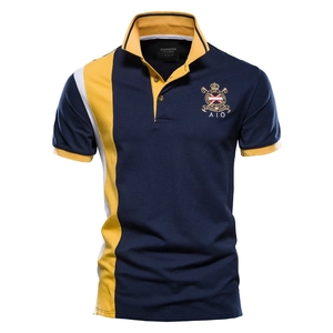 Detail of navy blue cotton polo shirt featuring gold embroidery and yellow side panels