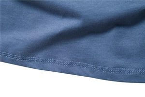 Detail shot of blue cotton fabric hem with precise double-needle stitching on long sleeve T-shirt