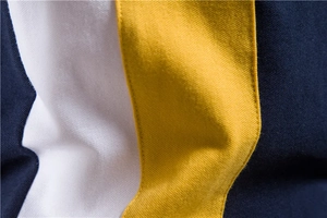Detailed close-up of navy, white, and yellow vertical stripe pique knit polo shirt fabric