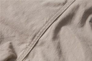 Detail of khaki cotton chinos showing double-stitch seams and premium twill texture