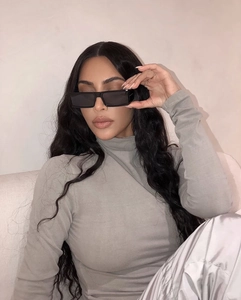 Gros plan sur les lunettes de soleil rectangulaires noires portées par un mannequin chic