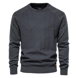 Detail of dark grey crew neck knit sweater with textured herringbone pattern and ribbed cuffs