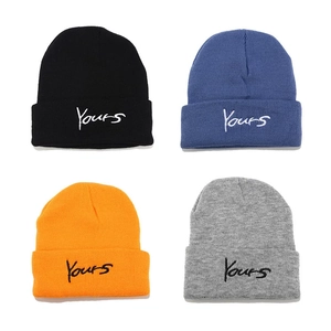 Close-up of Yours embroidered letters on four colors of wool knit beanies
