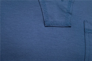 Detail of reinforced double stitching on navy blue cotton T-shirt fabric