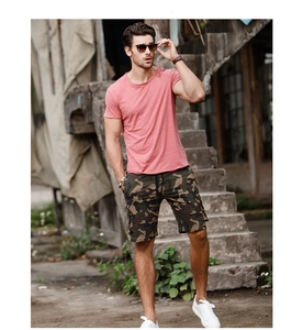 Outdoor shot of men's pink short sleeve T-shirt paired with camouflage cargo shorts