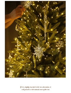 Detail of clear acrylic snowflake and icicle ornaments on a warm lit Christmas tree