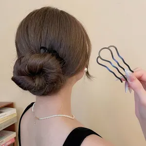 Épingle à cheveux ondulée noire mate en U pour chignon sur une coiffure de femme