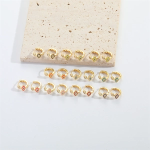 Detailed collection of gold hoop earrings with colorful enamel evil eye charms and diamonds