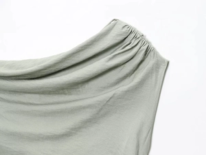 Détail de l'encolure dos nu vert sauge avec texture de tissu plissée et coutures fines
