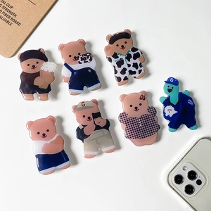 Collection of cute cartoon bear and dinosaur expandable phone sockets on white desk