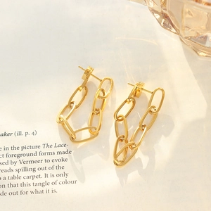 Bohemian gold titanium steel chain link earrings on minimalist paper background