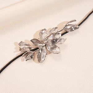 Détail de breloque tulipe en métal argenté avec accessoire en lanière de cuir noir