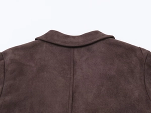 Detailed close-up of brown faux suede jacket collar and shoulder texture on white background