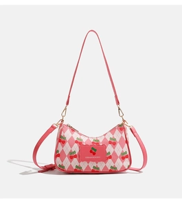 Détail du motif à losanges rose avec accents cerise rouge sur un sac en cuir PU