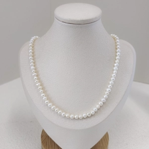 Elegant natural freshwater pearl necklace displayed on a mannequin jewelry stand