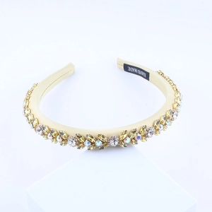 Close-up of handmade baroque headband with colorful rhinestones on champagne satin fabric