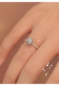 Macro shot of flower-shaped diamond ring with side stones on a finger