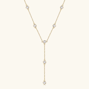 Detailed view of a gold S925 sterling silver Y-shaped necklace with seven round moissanite stones