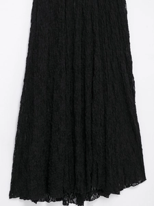 Detail of black lace texture and ruffled wavy hemline on this elegant maxi skirt