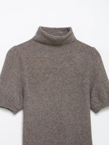 Detail view of the soft ribbed texture on a brown high-neck short sleeve knit dress