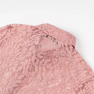 Close-up of the delicate floral lace texture and back collar on this pink polo shirt