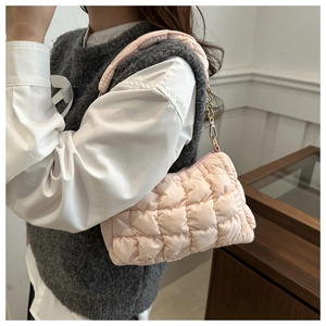Detail of pink quilted cloud shoulder bag with thick strap and gold chain decoration