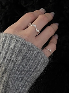 Detailed close-up of S925 silver wave ring and minimalist pearl finger ring on hand