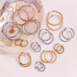 Detailed shot of gold and silver hoop earrings with rhinestones inside a seashell backdrop