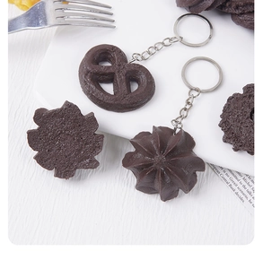 Detail of dark chocolate cookie keychain with heart and star shapes on a plate