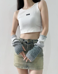 Detail of grey gradient wool knit arm warmer sleeves on a model in a natural pose
