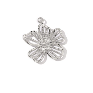 Macro view of silver hollow flower pendant with ring loop for DIY jewelry making