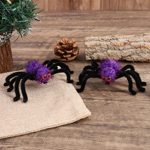 Pair of purple plush Halloween spider hair clips with red eyes on a natural wooden surface