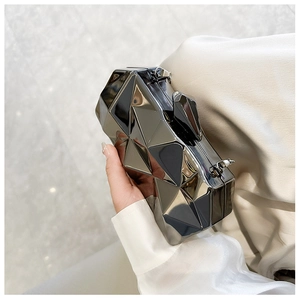 Close-up of gunmetal grey geometric faceted acrylic evening clutch held in hand