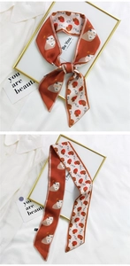 Close-up of artistic silk twilly ribbon with abstract faces and retro brick red patchwork