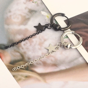 Detail of silver and black stainless steel star pendant earrings with dangling chain links