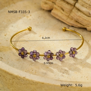 Dettaglio bracciale dorato con fiori in zircone viola e diametro interno di 6,2 cm