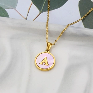 Gold letter A necklace with pink shell inlay on round stainless steel pendant